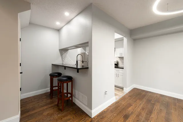 a view of hallway with wooden floor and furniture