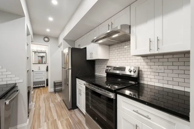 a kitchen with granite countertop a stove a sink dishwasher and a refrigerator
