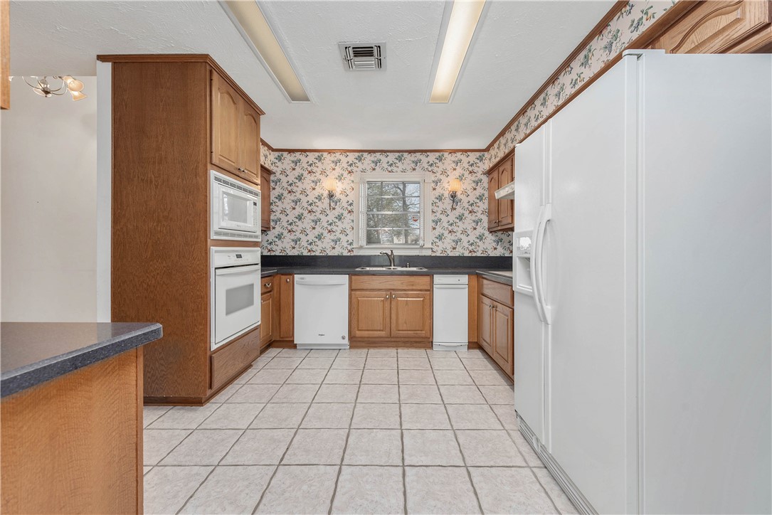 12994 Hunters Creek Road College Station, TX 77845 - Photo 11 of 35 a kitchen with a stove a sink and a refrigerator