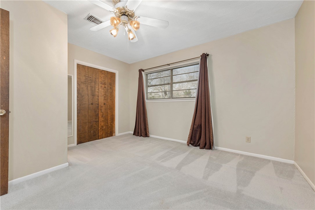12994 Hunters Creek Road College Station, TX 77845 - Photo 21 of 35 a view of a room with closet and chandelier fan