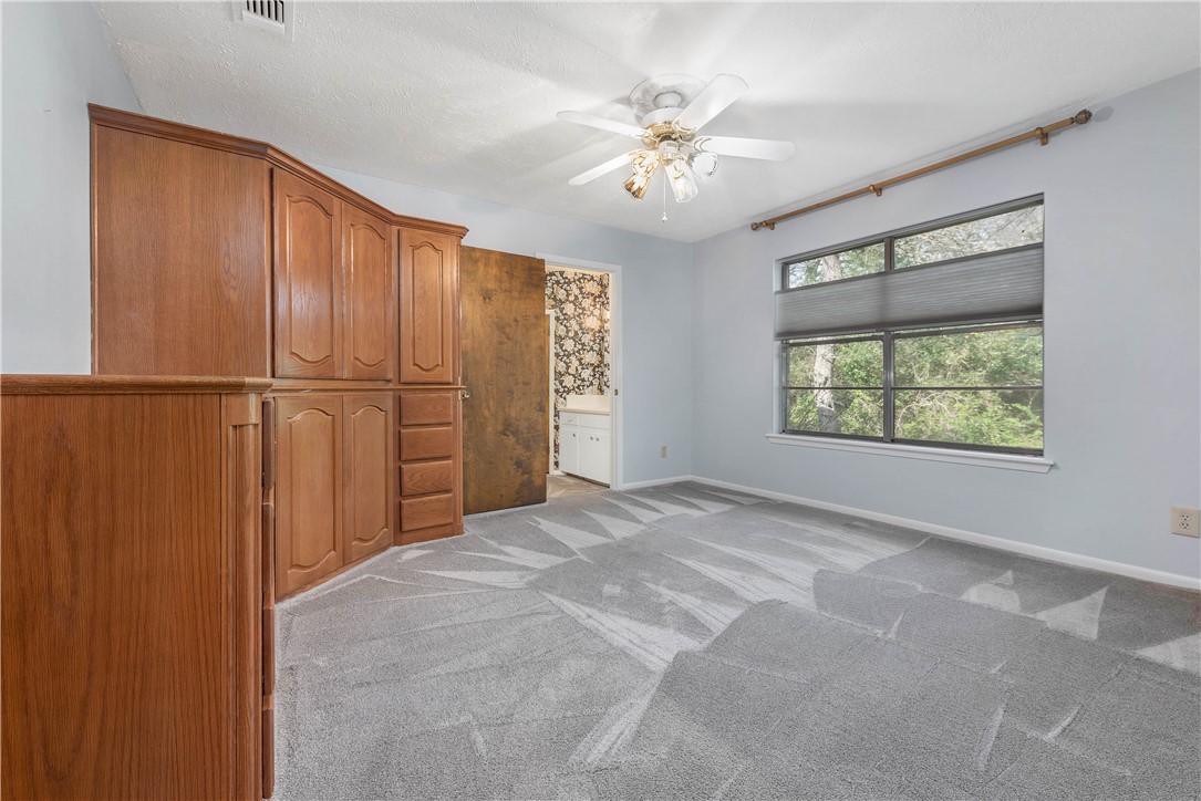 12994 Hunters Creek Road College Station, TX 77845 - Photo 26 of 35 an empty room with chandelier fan and windows