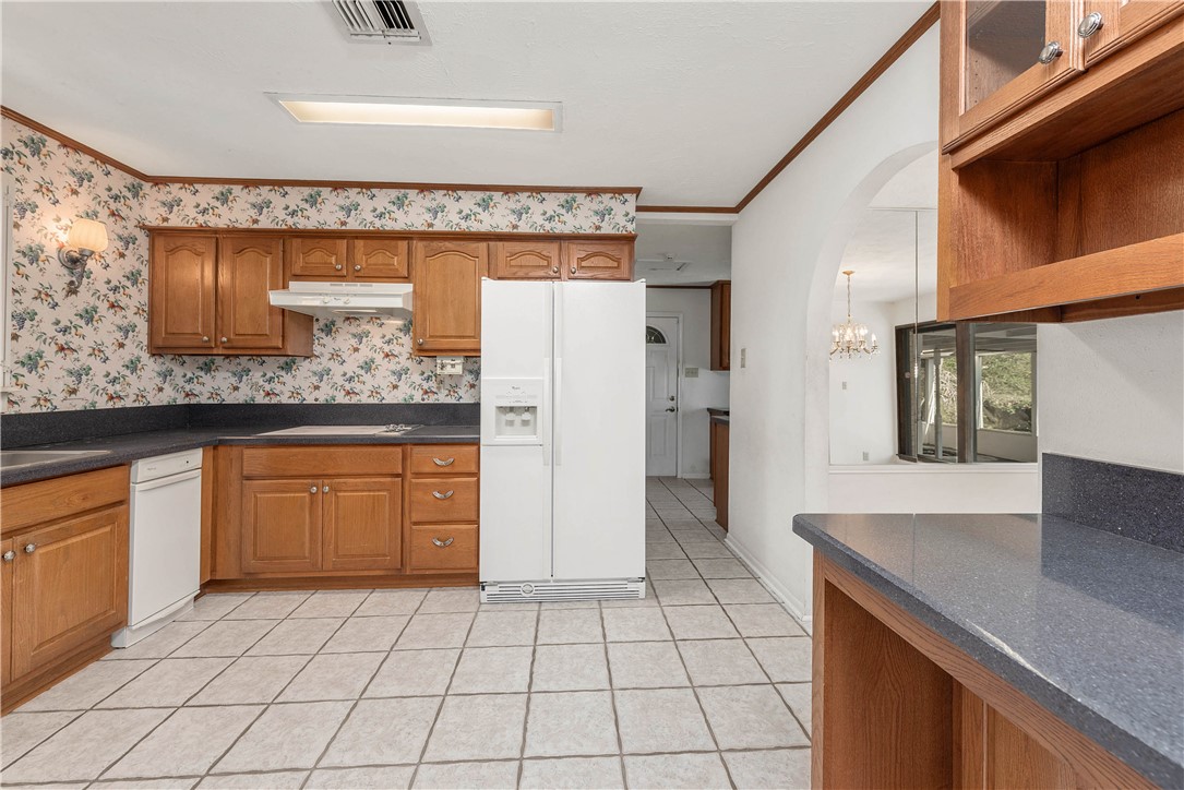 12994 Hunters Creek Road College Station, TX 77845 - Photo 10 of 35 a kitchen with granite countertop a sink and a refrigerator
