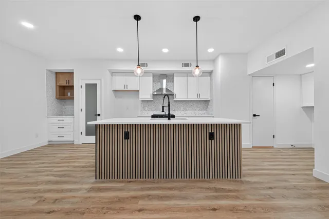 a view of kitchen with stainless steel appliances granite countertop a sink a oven a stove and a wooden floors