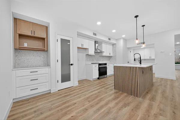 a kitchen with stainless steel appliances granite countertop a sink dishwasher a refrigerator and a oven with wooden floor