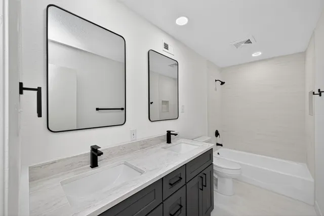 a bathroom with a double vanity sink double mirror and bathtub