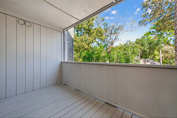 a view of a balcony with wooden floor and plant
