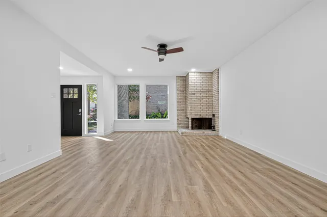 an empty room with windows and fireplace