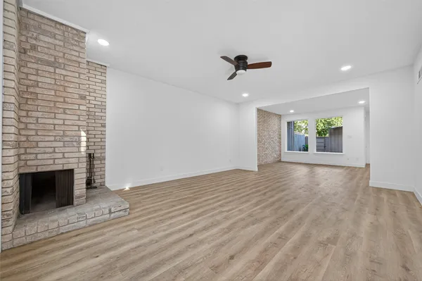 a view of an empty room with a fireplace and a window