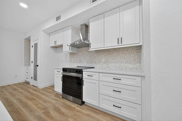 a kitchen with stainless steel appliances granite countertop white cabinets and a sink