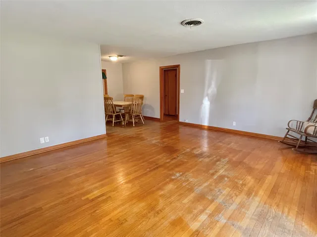 a view of a room with wooden floor and bench