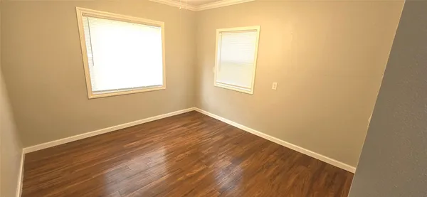 an empty room with wooden floor and a window