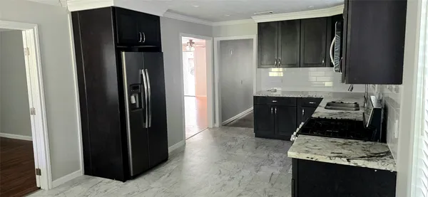 a kitchen with a refrigerator and a stove