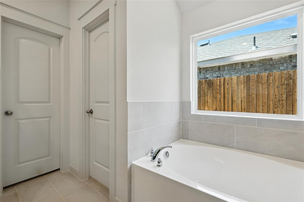 1795 Gleasondale Place Forney, TX 75126 - Photo 17 of 29 Full bath with a garden tub and light tile patterned floors