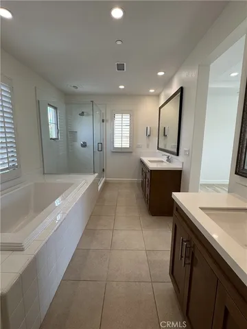 a spacious bathroom with a tub sink and mirror