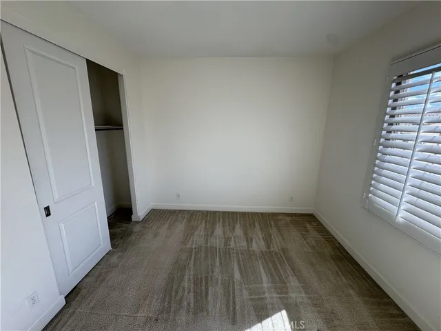 an empty room with wooden floor and white walls