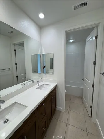 a bathroom with a granite countertop sink a mirror and a bathtub