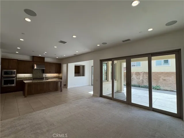 a living room with stainless steel appliances furniture and a kitchen