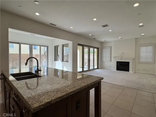 a kitchen with granite countertop kitchen island a sink appliances and a counter space