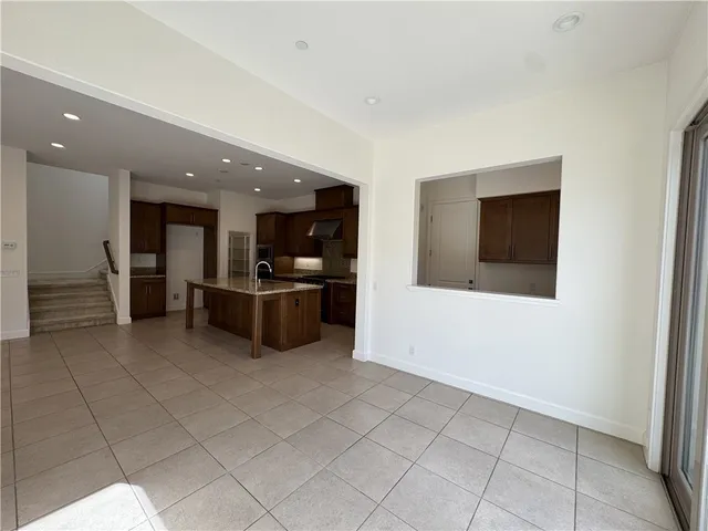 a kitchen with stainless steel appliances kitchen island granite countertop a refrigerator and a stove top oven