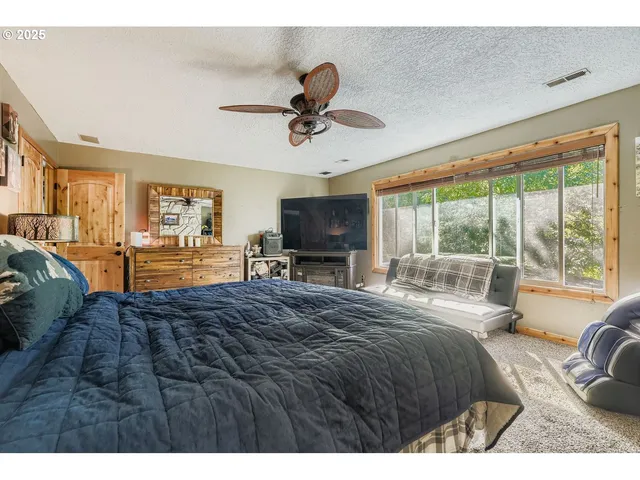 a bedroom with a bed and large windows