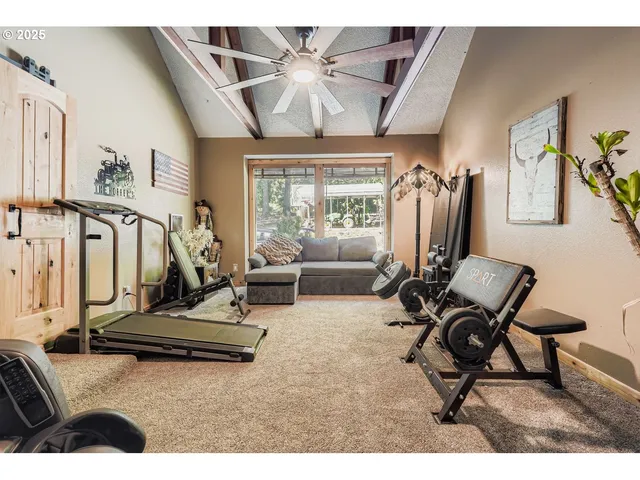 a living room with furniture gym equipment and a large window