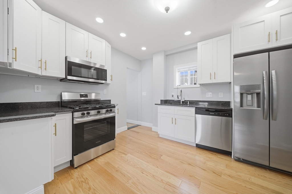 7 Pine Street Stoneham, MA 02180 - Photo 6 of 23 a kitchen with stainless steel appliances granite countertop a stove a sink and a refrigerator