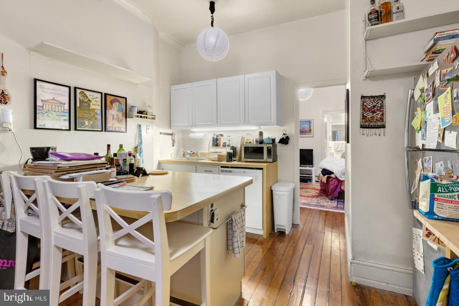 4713 Baltimore Avenue, Unit 1 Philadelphia, PA 19143 - Photo 5 of 22 a kitchen with a dining table chairs sink and cabinets