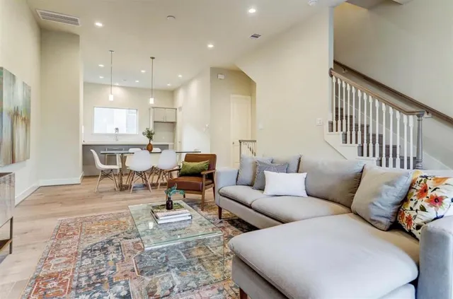 a living room with furniture and a wooden floor
