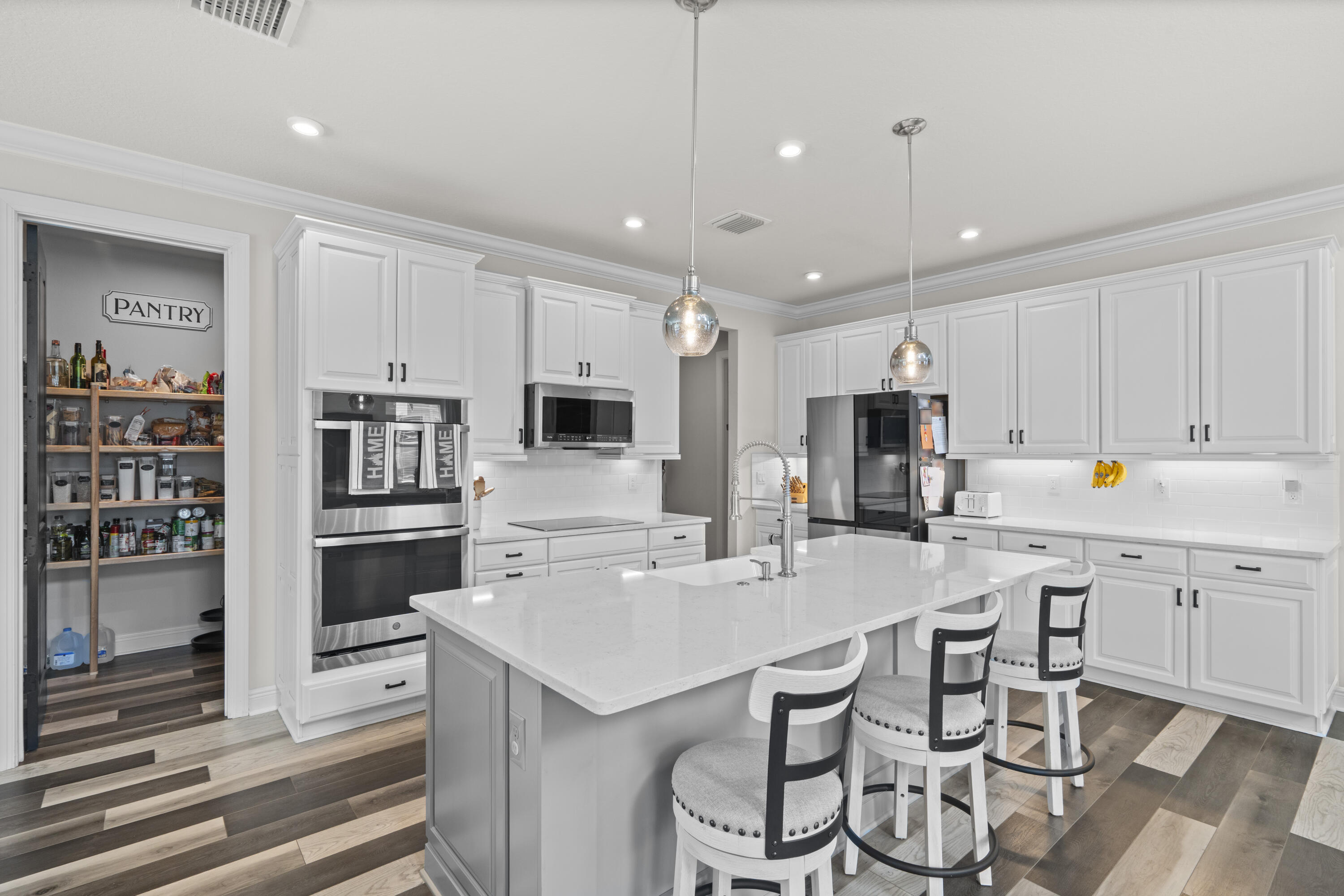 684 Southwest Pennfield Terrace Stuart, FL 34997 - Photo 13 of 61 a kitchen with a sink stainless steel appliances and white cabinets