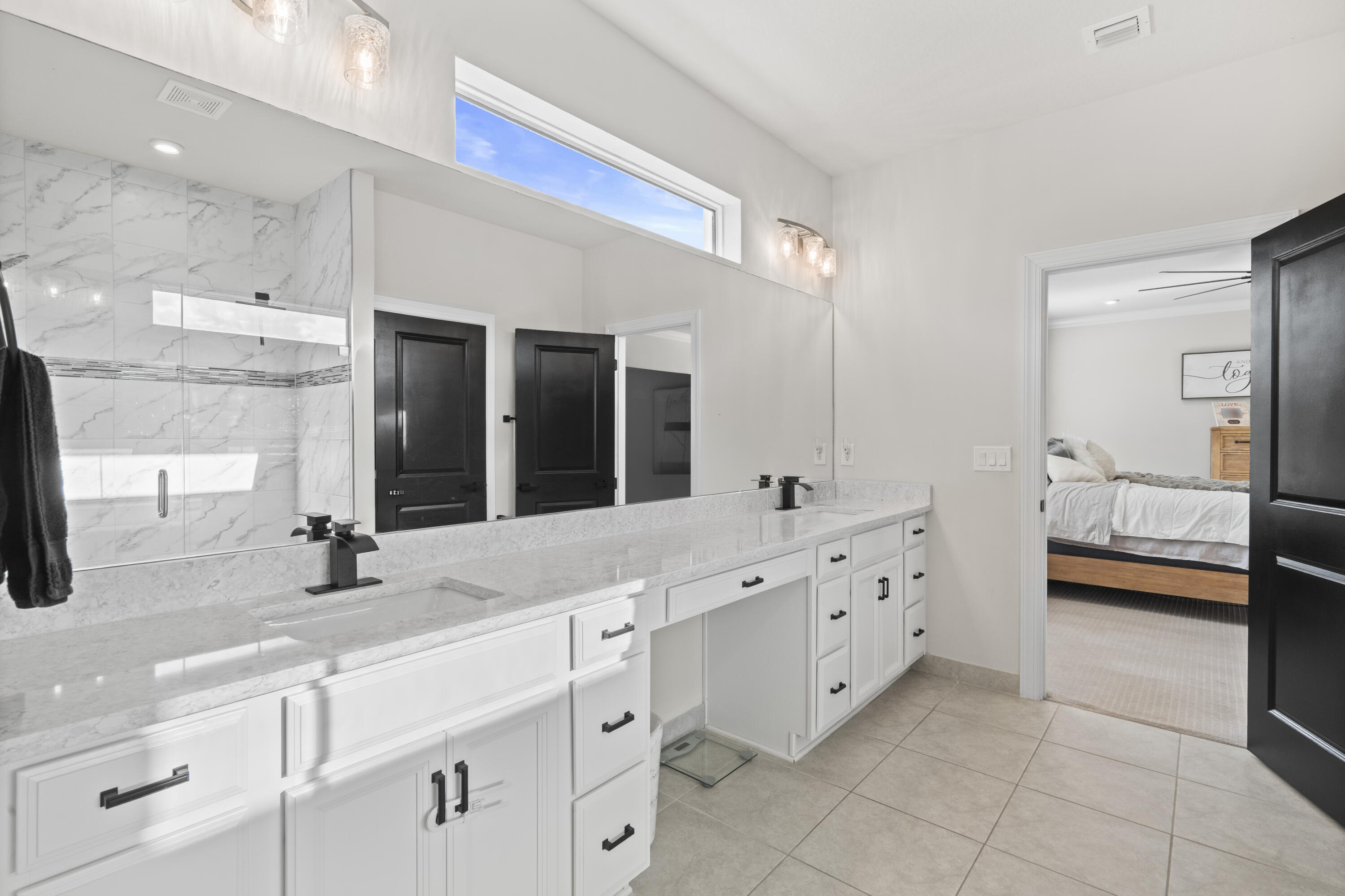 684 Southwest Pennfield Terrace Stuart, FL 34997 - Photo 27 of 61 a bathroom with a double vanity sink a mirror and a