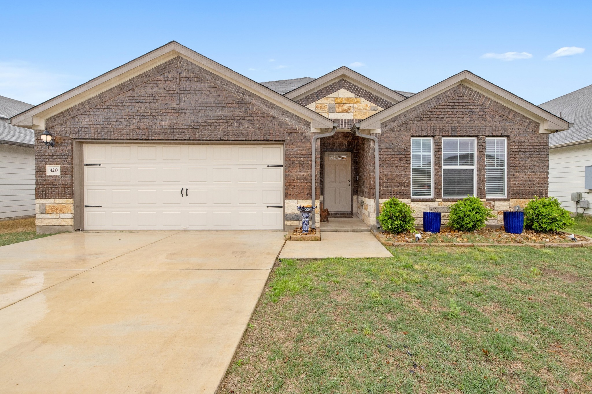420 Windy Reed Road Hutto, TX 78634 - Photo 1 of 1 Ranch-style home with brick siding, a front yard, driveway, and a garage