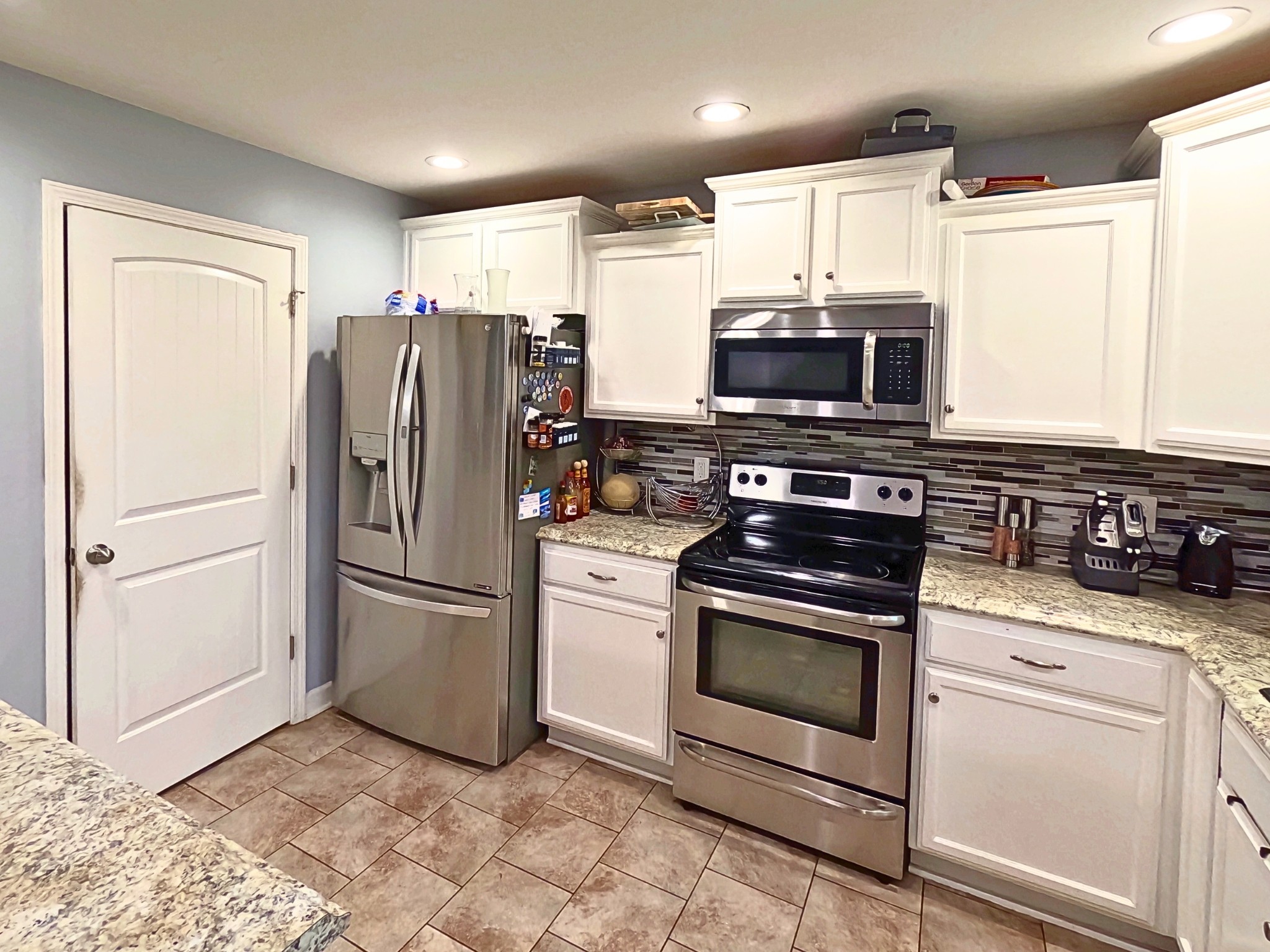 4631 Turquoise Lane Murfreesboro, TN 37129 - Photo 10 of 42 a kitchen with granite countertop a refrigerator stove and microwave