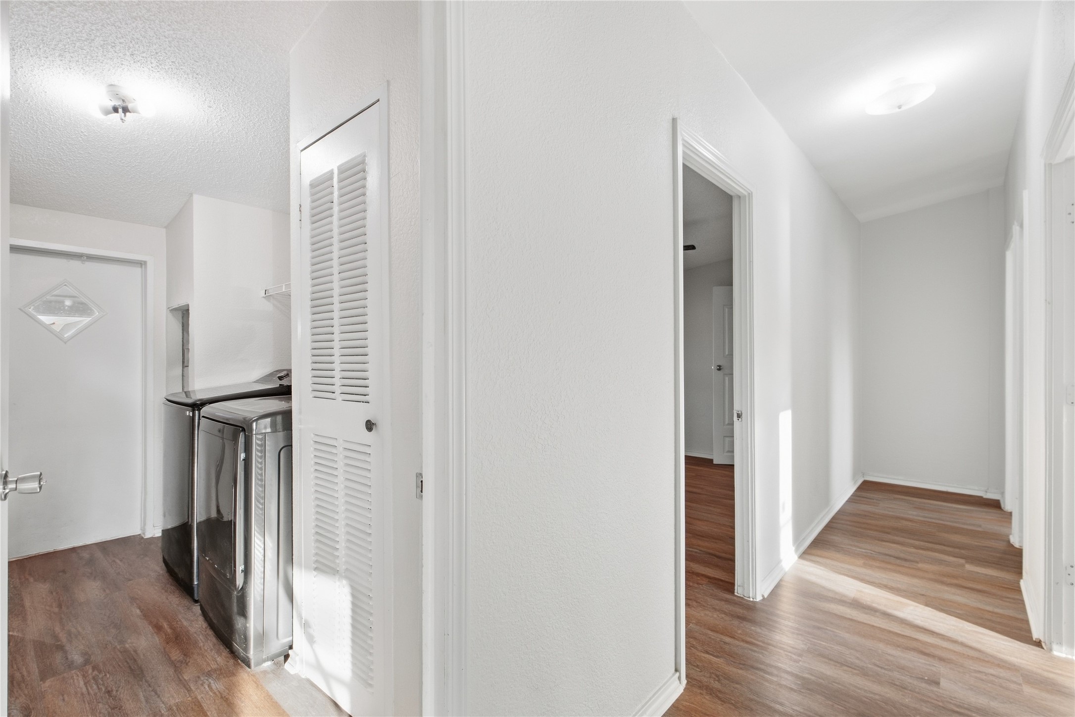 2709 County Road 463 Elgin, TX 78621 - Photo 22 of 32 Gleaming wood-look floors connect a convenient utility nook with the main residential hallway.