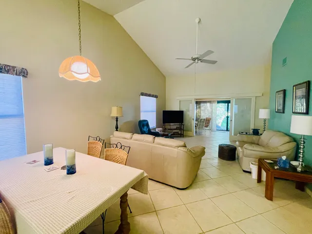 a living room with furniture a flat screen tv and a table