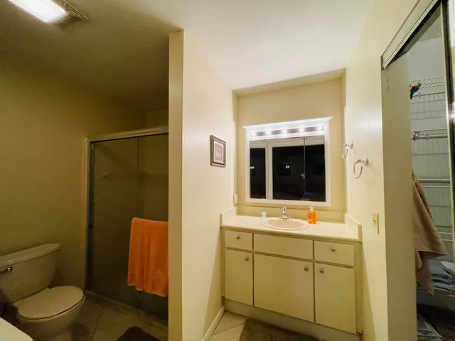 a bathroom with a granite countertop sink toilet and shower