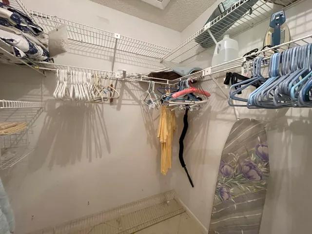a view of walk in closet with clothes and shoes