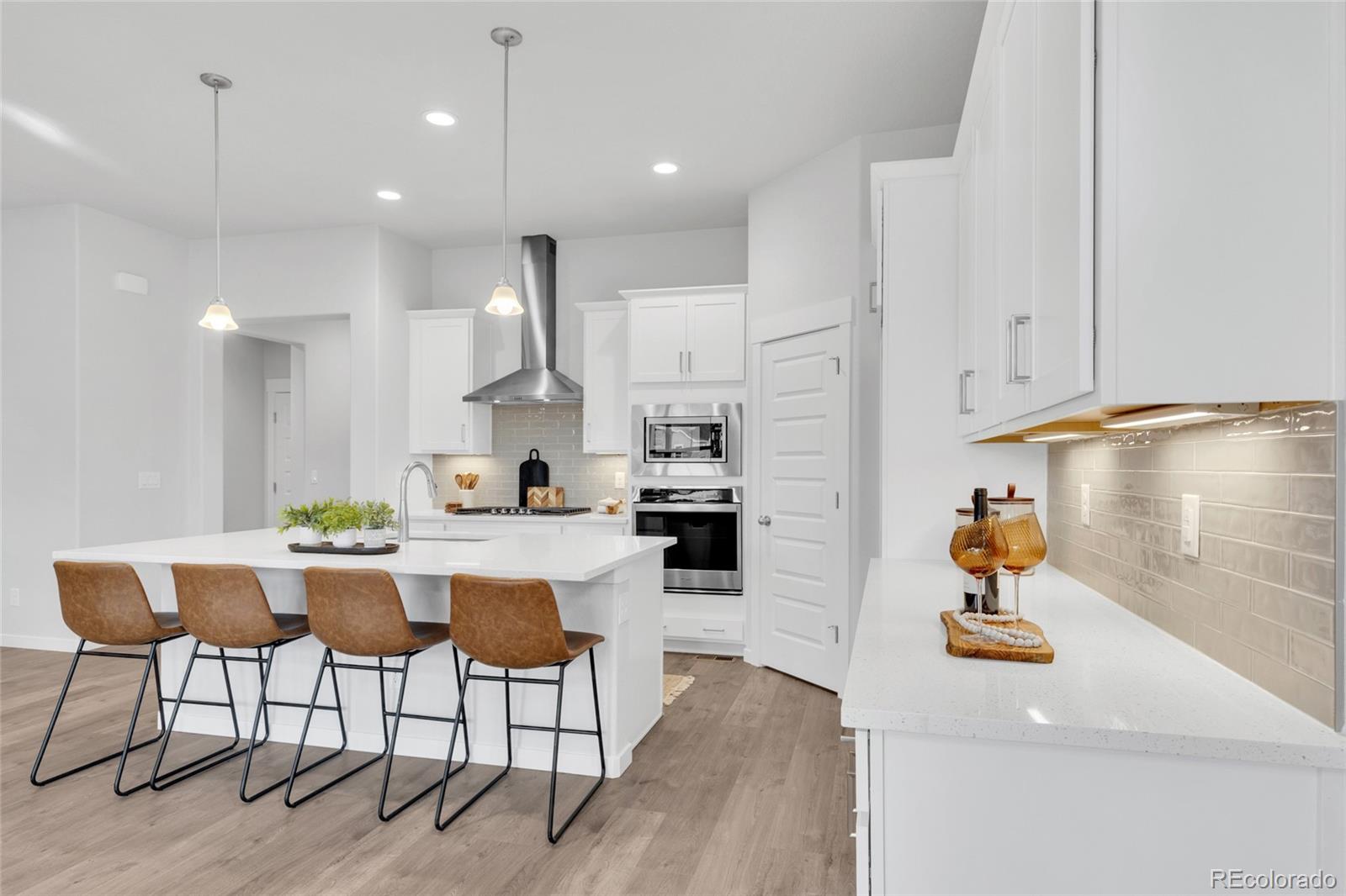 8878 South Riviera Court Aurora, CO 80016 - Photo 12 of 31 a kitchen with white cabinets and chairs