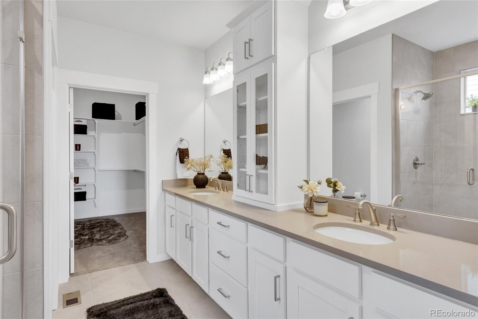 8878 South Riviera Court Aurora, CO 80016 - Photo 18 of 31 a spacious bathroom with double vanity sinks a mirror and a shower