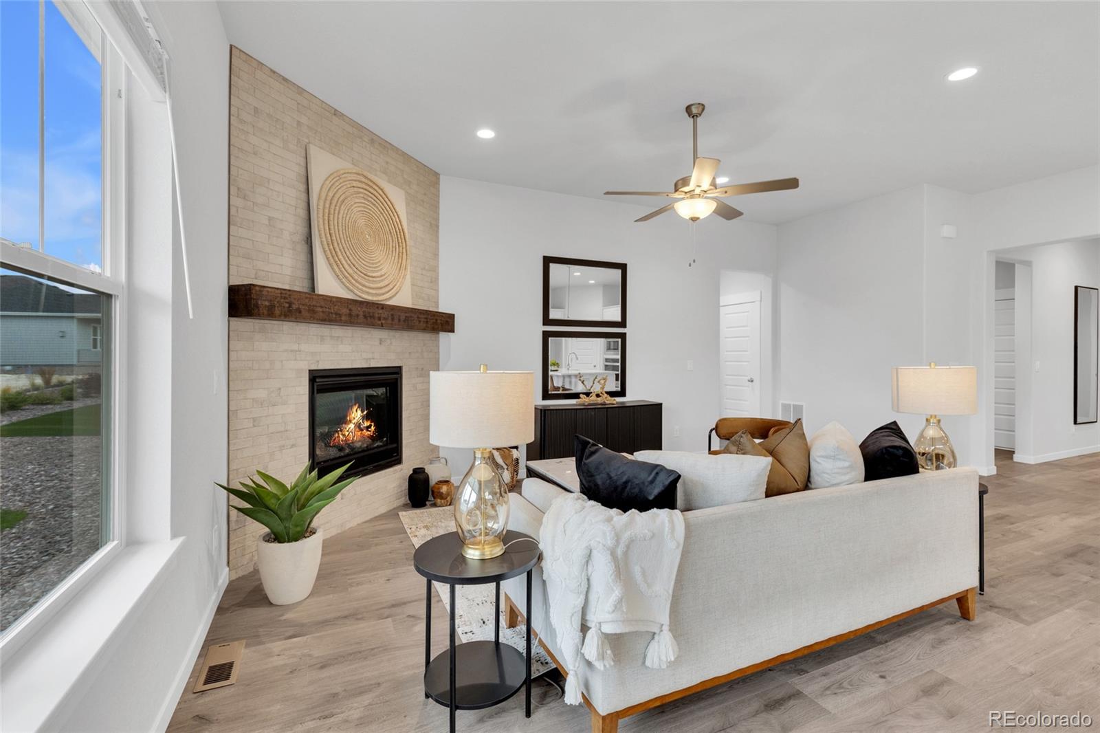 8878 South Riviera Court Aurora, CO 80016 - Photo 7 of 31 a living room with furniture a fireplace and a chandelier
