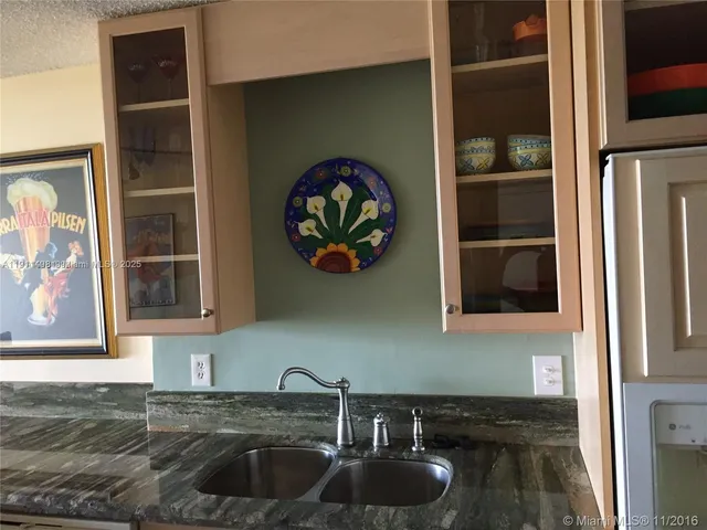 a kitchen with a sink and a stove with wooden floor