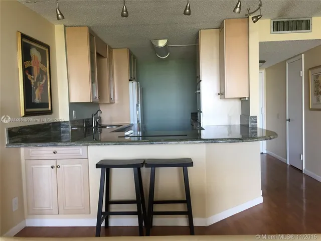 a kitchen with a table chairs sink and cabinets