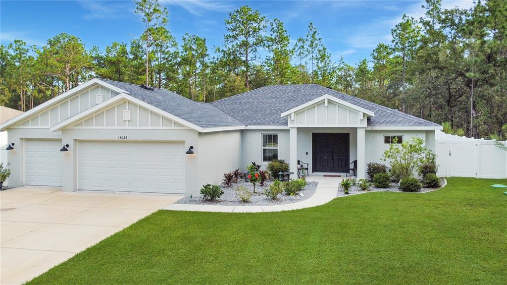 13023 Downy Woodpecker Road Weeki Wachee, FL 34614 - Photo 2 of 43 a front view of a house with a garden and yard