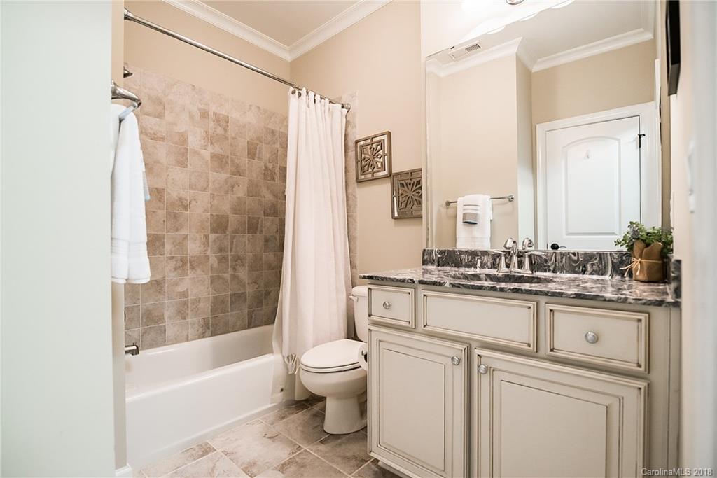 8116 Balcony Bridge Road Huntersville, NC 28078 - Photo 22 of 31 a bathroom with a granite countertop sink a toilet a mirror a bathtub and shower