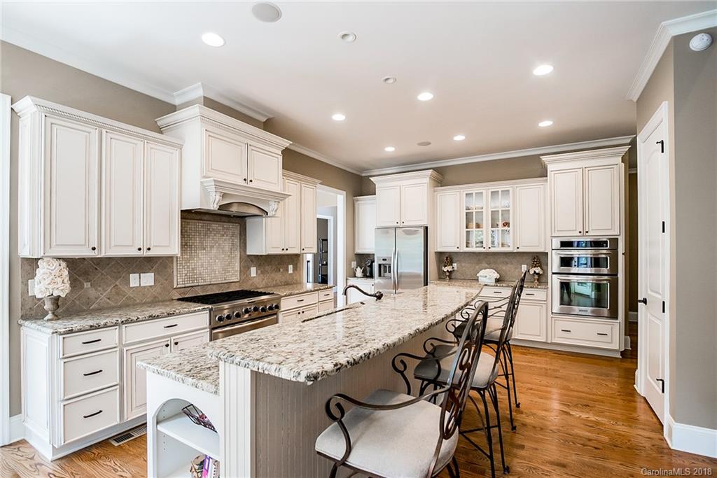 8116 Balcony Bridge Road Huntersville, NC 28078 - Photo 8 of 31 a kitchen with stainless steel appliances granite countertop a stove a sink a refrigerator white cabinets with wooden floor