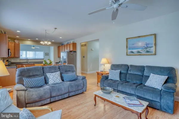 a kitchen with stainless steel appliances granite countertop a stove top oven a sink dishwasher and white cabinets with wooden floor