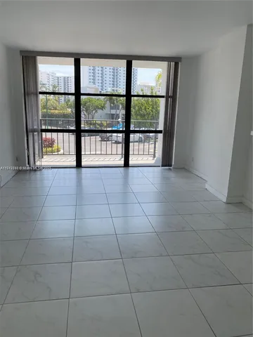 a view of an empty room with a floor to ceiling window and an empty room