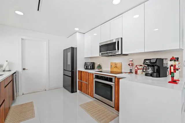 a kitchen with stainless steel appliances granite countertop a refrigerator stove and sink