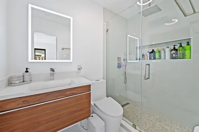 a bathroom with a granite countertop sink toilet and shower