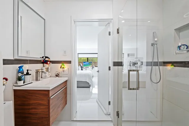 a bathroom with a double vanity sink mirror and shower