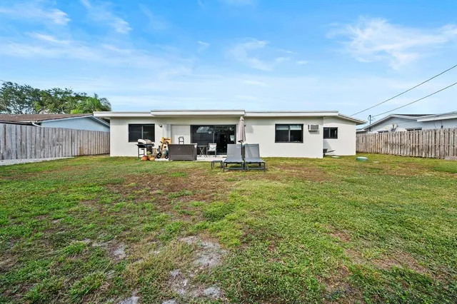 a view of a house with a yard and sitting area